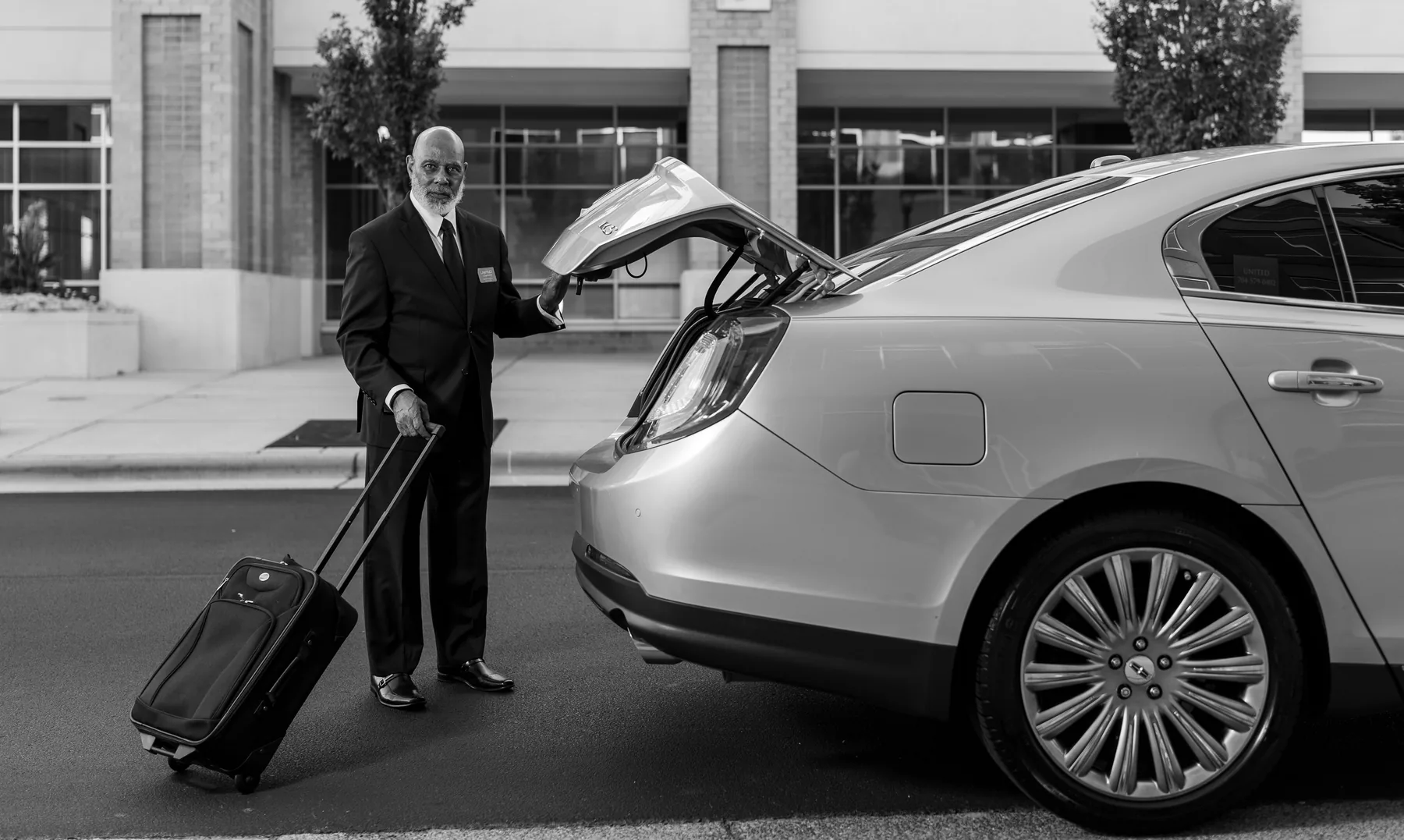 Representative chauffeur preparing luggage for a longer car journey