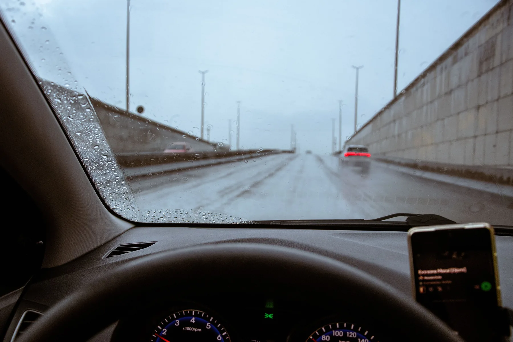 View from inside a car travelling on a rainy road