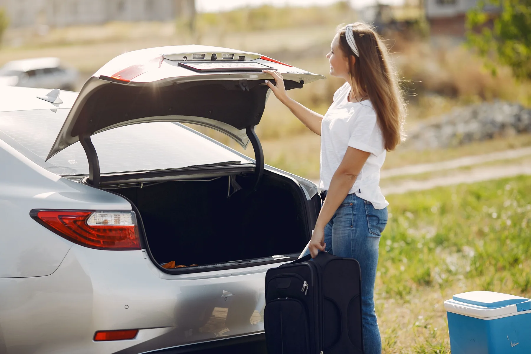 Traveller preparing luggage beside a car